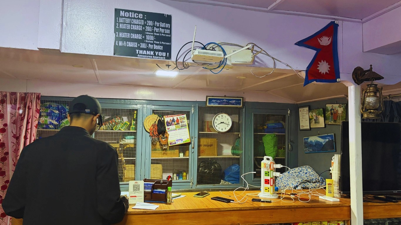 Counter inside the dining hall at Dovan displaying prices for hot showers, WiFi, and heater services for trekkers.
