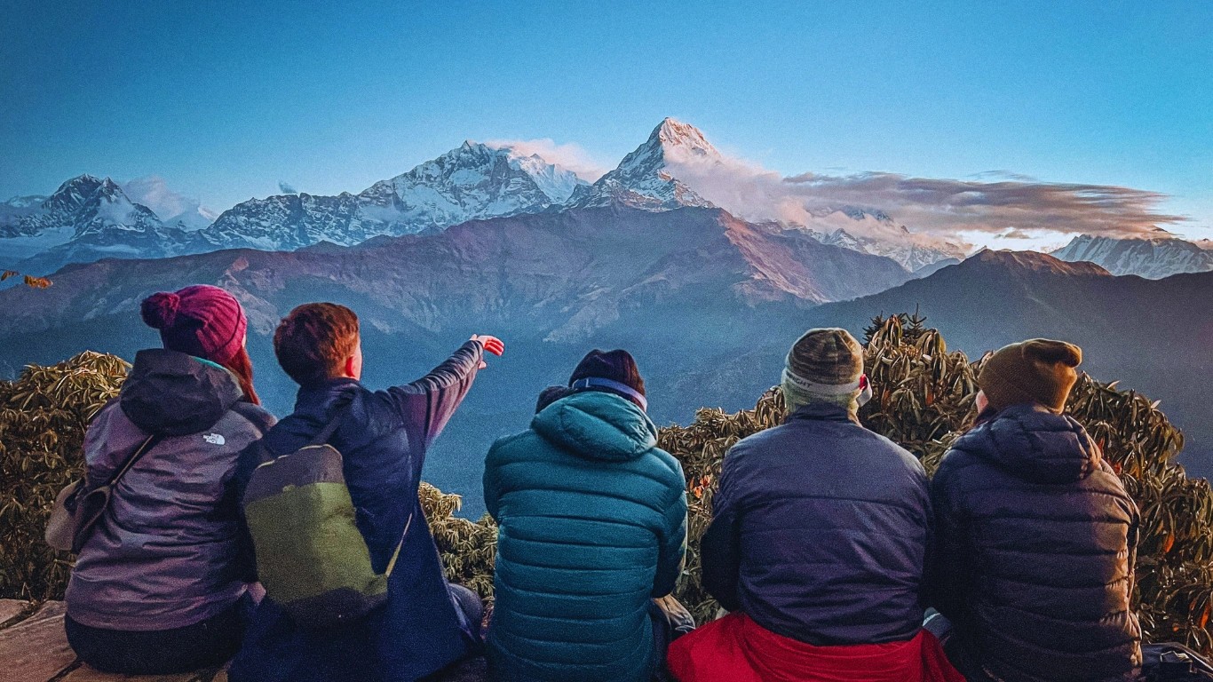 Trekkers enjoying sunrise views of the Annapurna range from Poon Hill during monsoon season