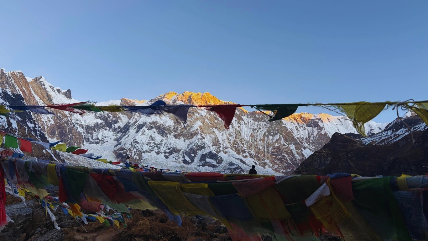 Colorful prayer flags with the glowing summit of Annapurna I in the background at Annapurna Base Camp.