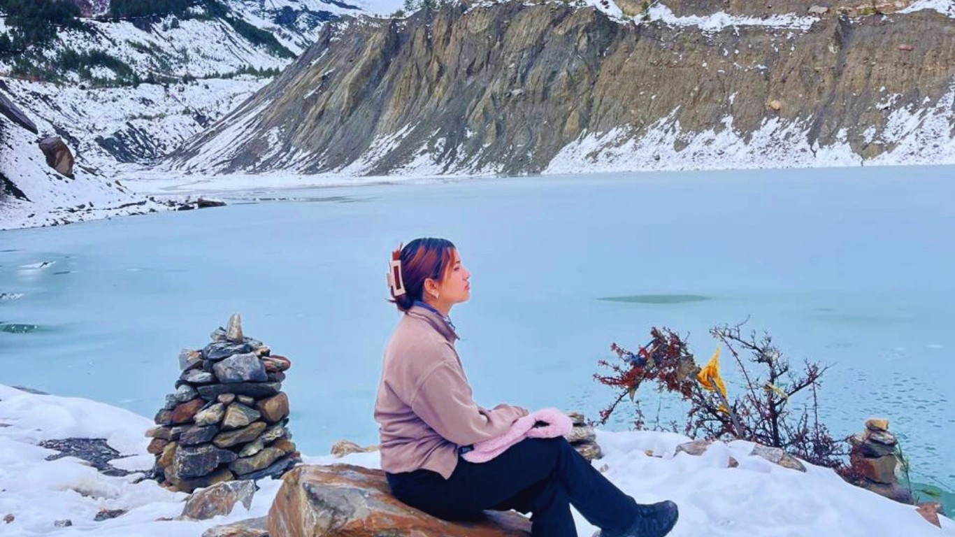 Female mountain guide Nepal Bibisika Raut sitting near a beautiful alpine lake