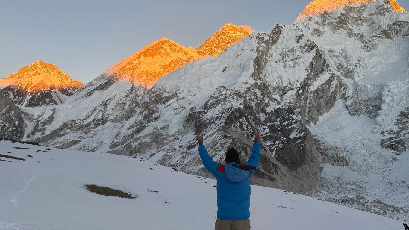 Senior trekker photographing Mount Everest at sunset between Gorak Shep and Kala Patthar during the Everest Base Camp Trek in Nepal.