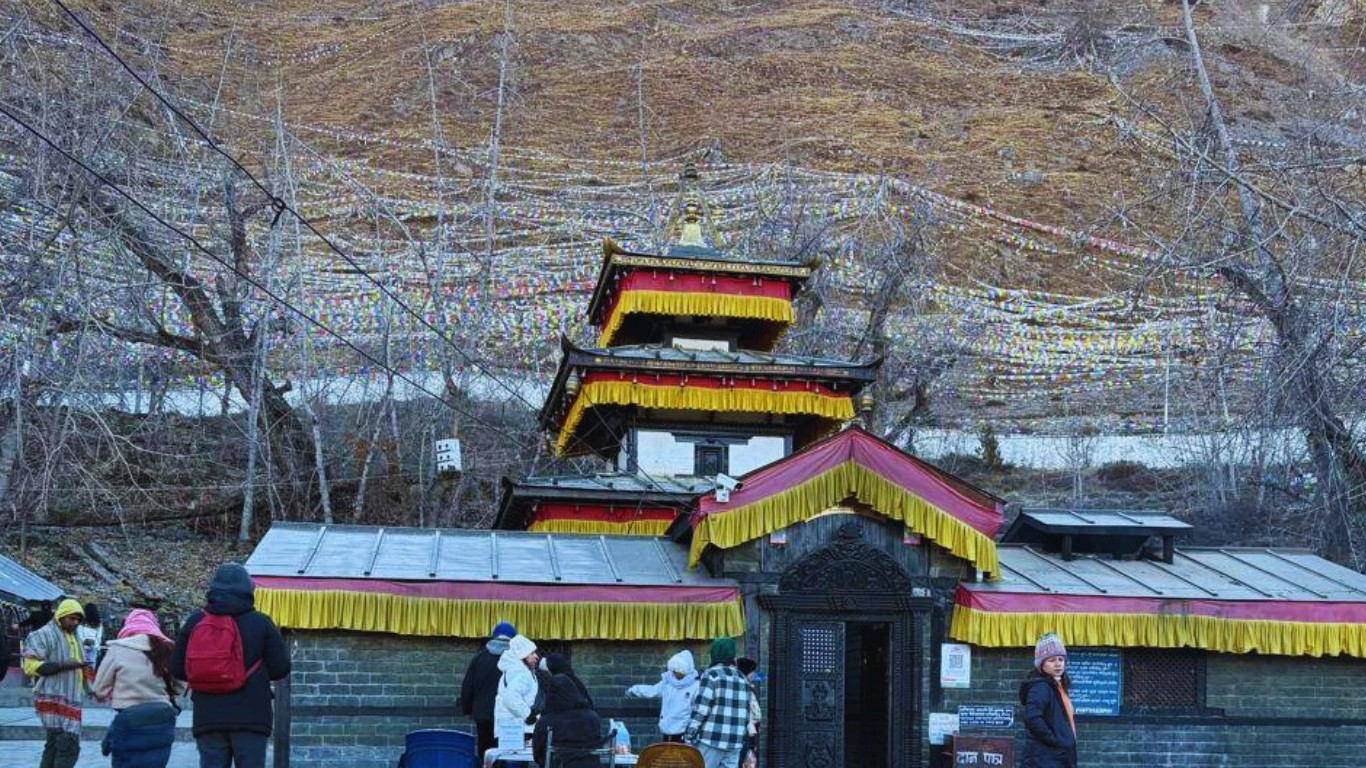 Early morning view of Muktinath Temple in Mustang, Nepal, with soft sunlight illuminating the temple complex and surrounding mountains.