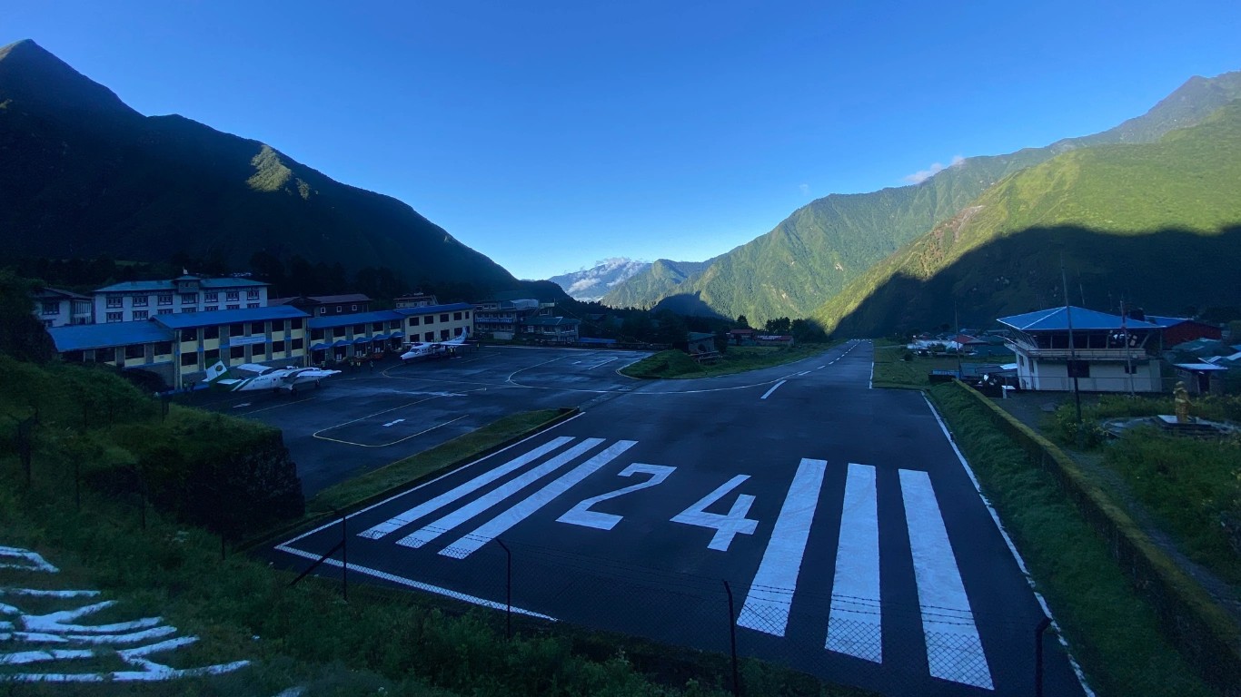 Lukla Airport surrounded by green hills under a clear August sky at the gateway to the Everest region in Nepal