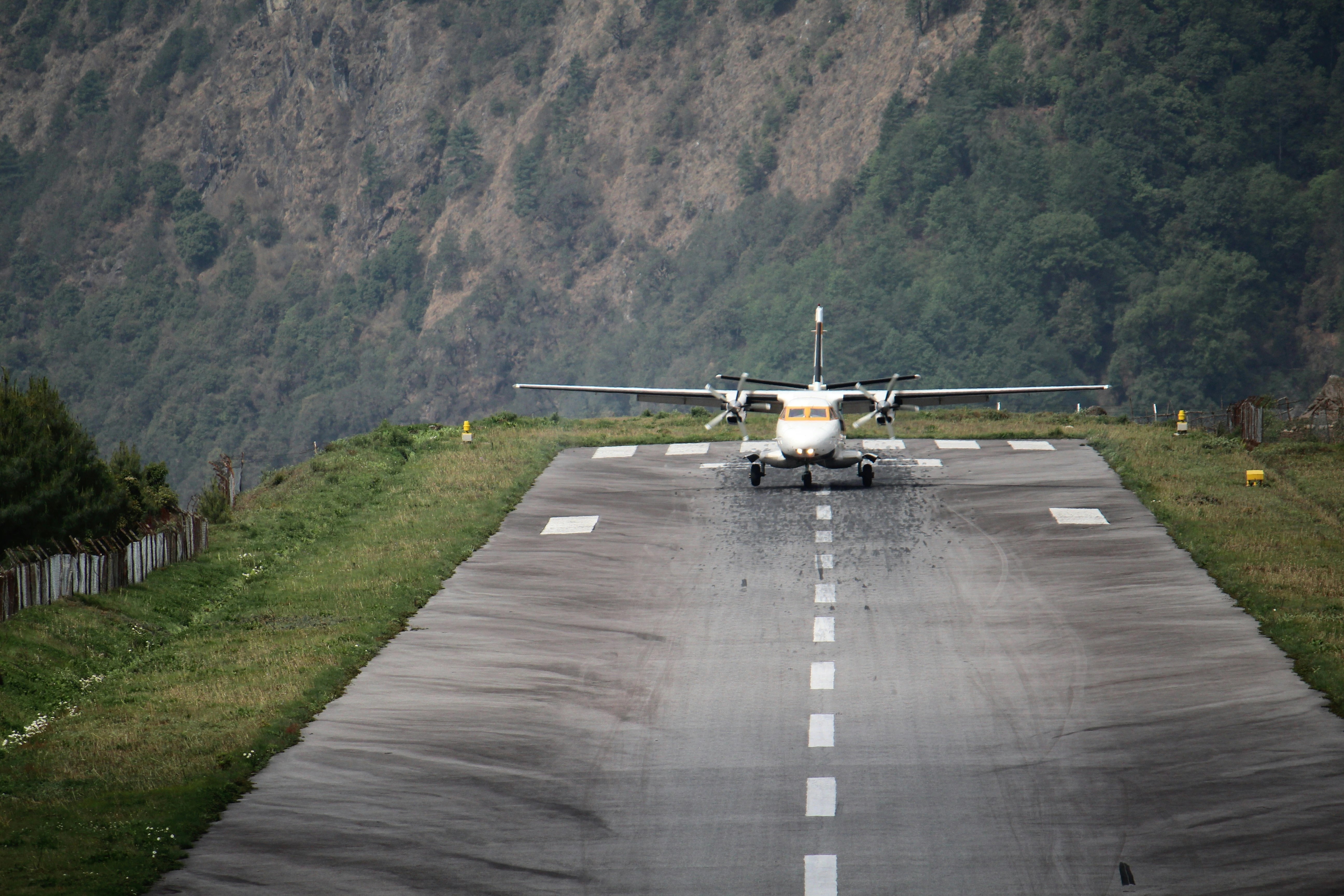 Small plane landing at Lukla Airport, the gateway to the Everest Base Camp Trek, with Himalayan mountains in the background.