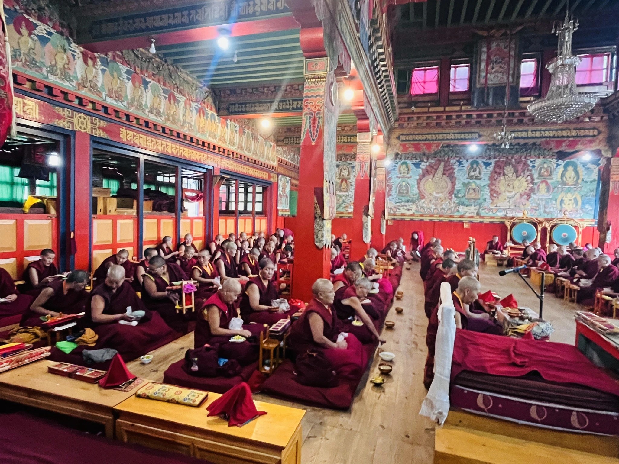 Monks praying inside Thubten Chholing Monastery in Solu-Khumbu, Nepal, performing traditional Tibetan Buddhist rituals