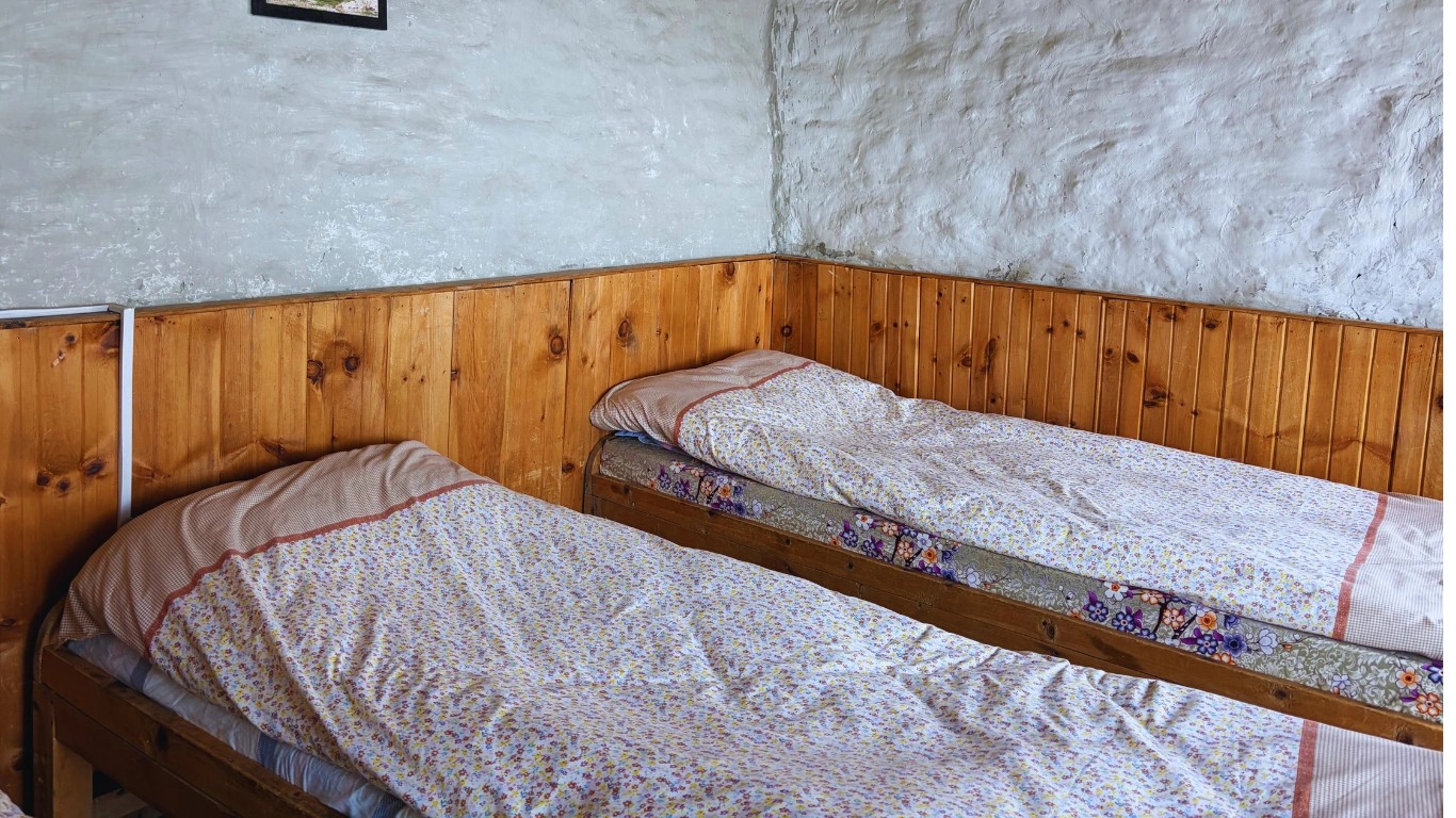 Two clean and comfortable beds inside Hilltop Hotel, Thorong Phedi on Annapurna Circuit Trek