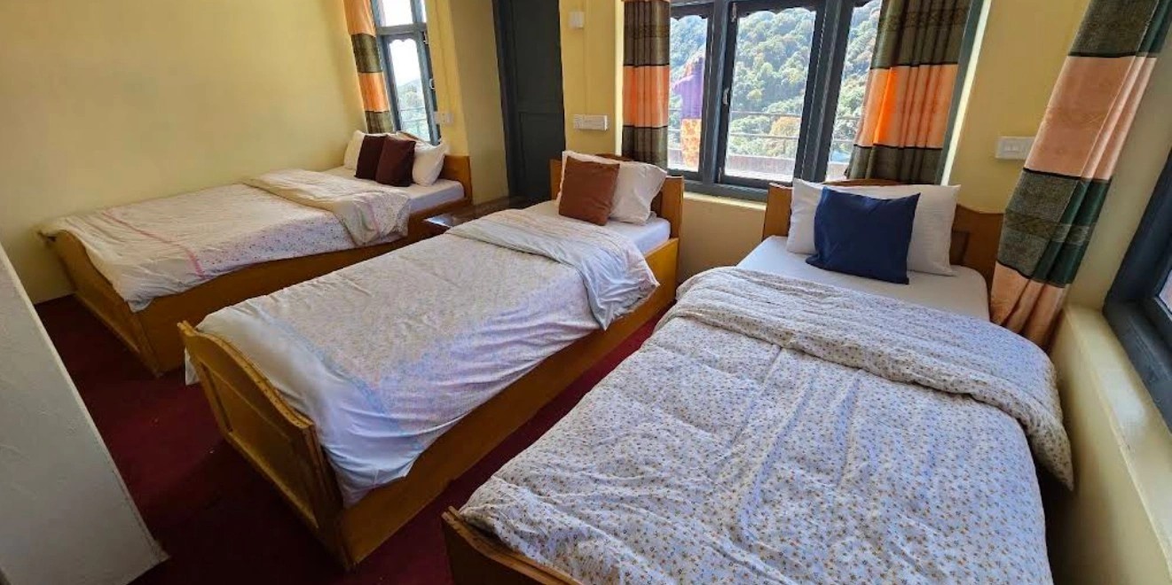 Wooden twin beds with blankets inside a teahouse room in Ghorepani during the Poon Hill trek.