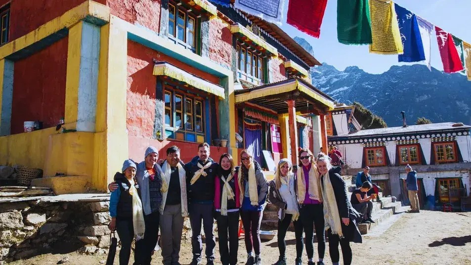 Luxury trekking group posing in front of Tengboche Monastery with the Himalayan peaks in the background