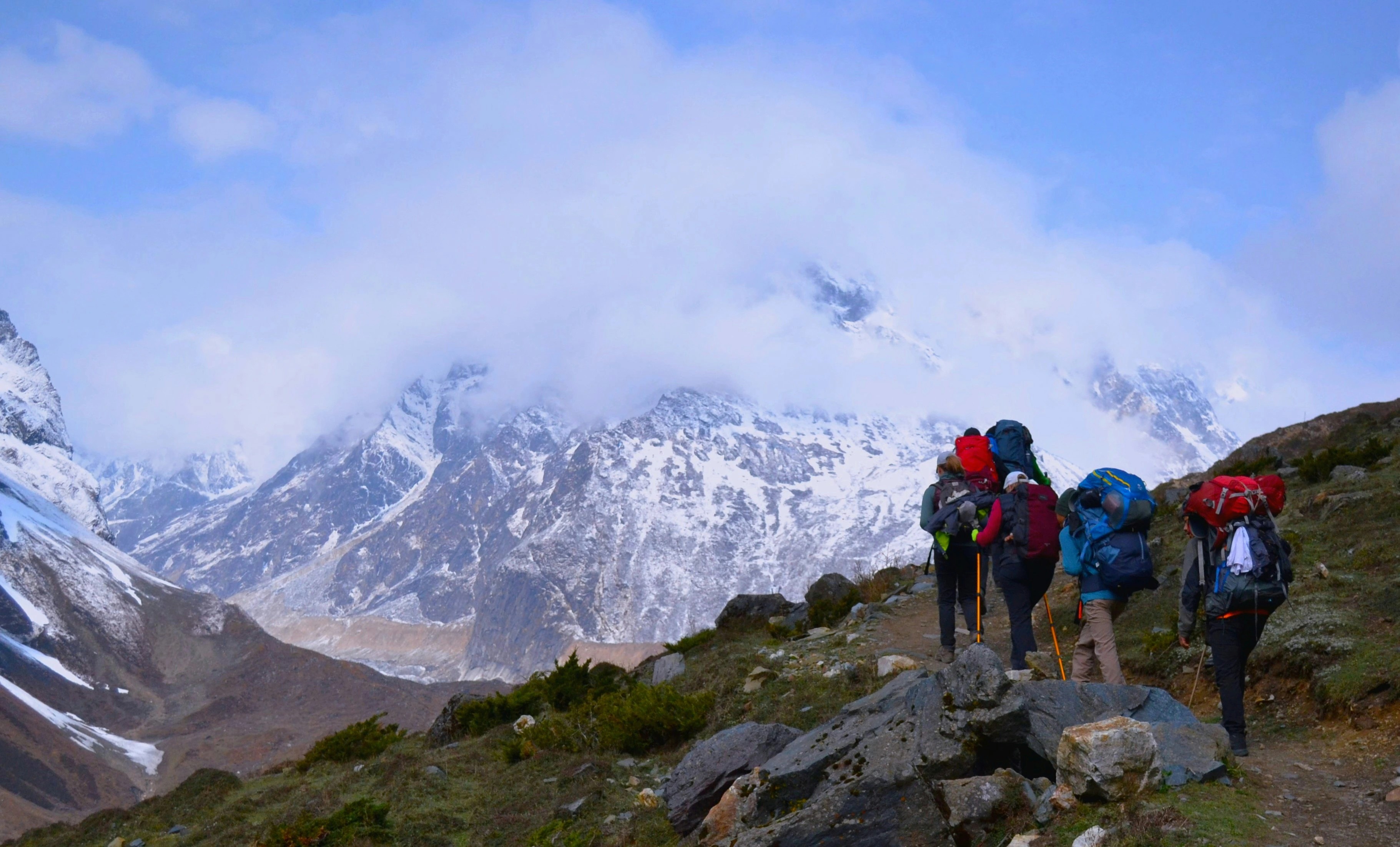 Group of trekkers walking along the trail to Tsum Valley surrounded by Himalayan scenery.