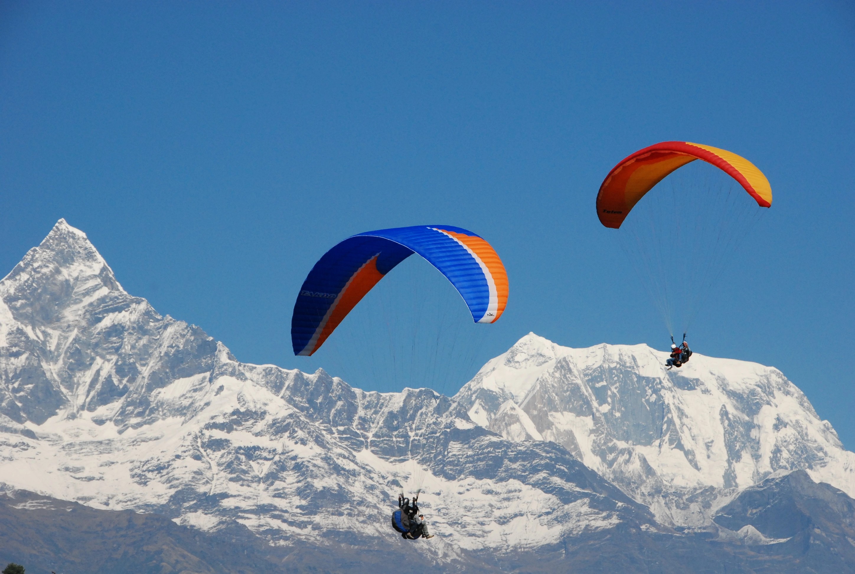 Paragliders flying over Phewa Lake in Pokhara with the Annapurna mountains reflected, captured on a 3 Night 4 Days Nepal trip