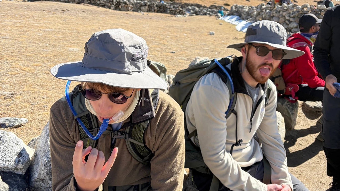Trekker drinking water to stay hydrated and support acclimatization on the Everest Base Camp Trek.