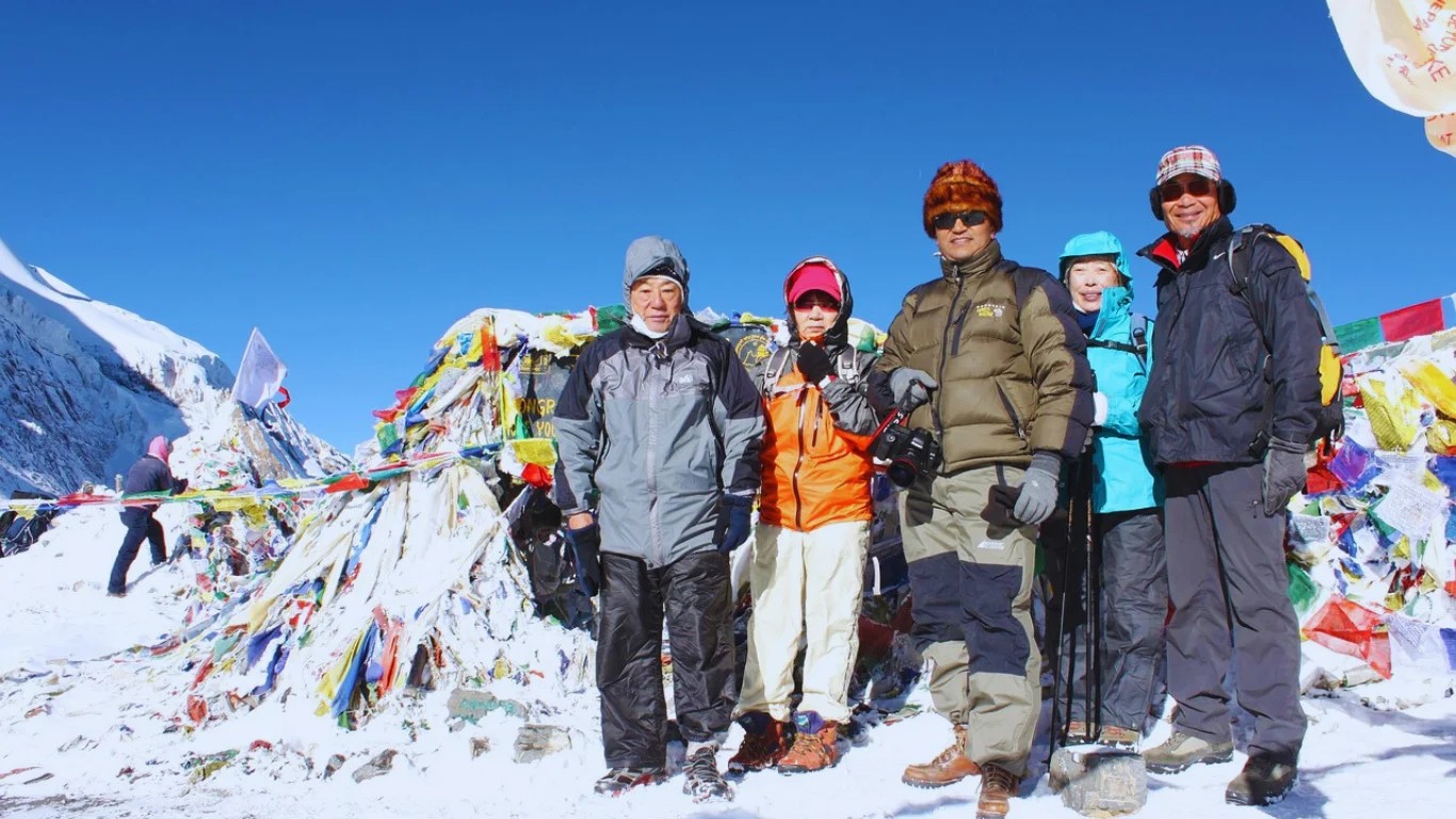 Group of trekkers celebrating at Thorong La Pass with annapurna circuit trek agency