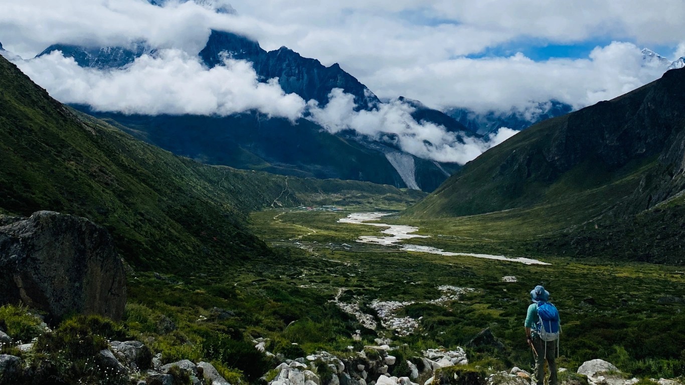 Trekkers posing on a lush green trail during the monsoon Everest Base Camp Trek with clouds covering the surrounding Himalayan peaks