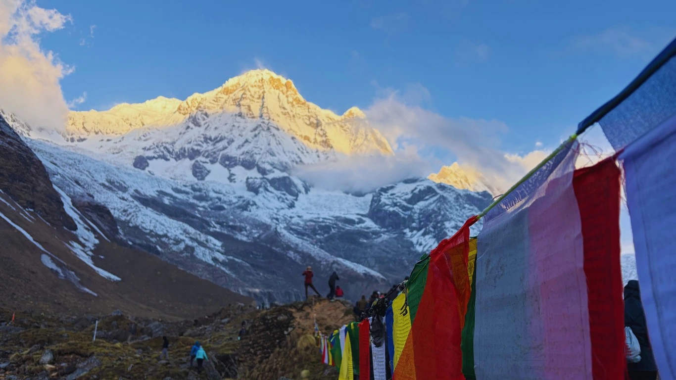 Golden sunrise illuminating the summit of Annapurna South with fresh snow covering the mountain peak.