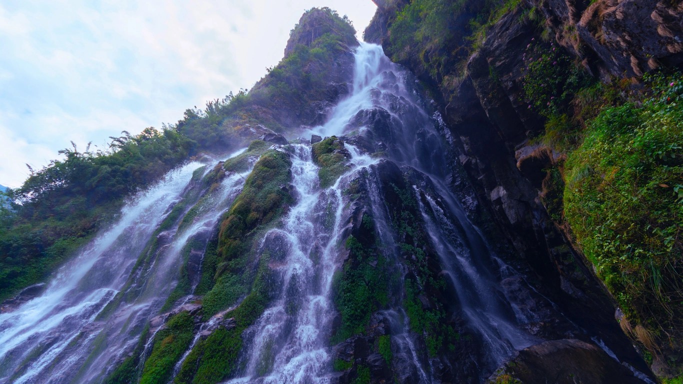 A powerful waterfall flowing beside the Annapurna Circuit trail during the monsoon season, highlighting the unique beauty and trekking conditions of the Annapurna Circuit in summer.