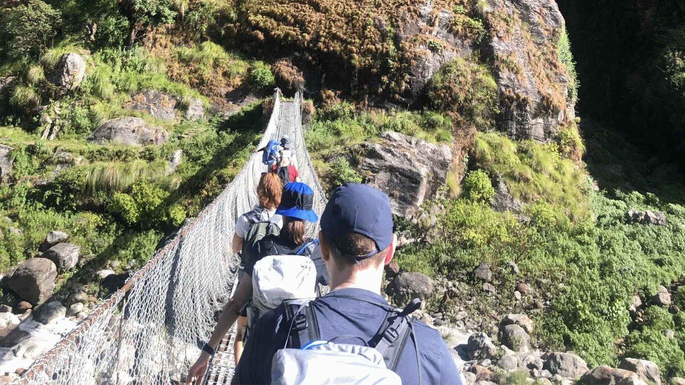 Majestic Trails Nepal guide leading trekkers on a NATT footpath through villages and mountain scenery on the Annapurna Circuit Trek in Nepal.