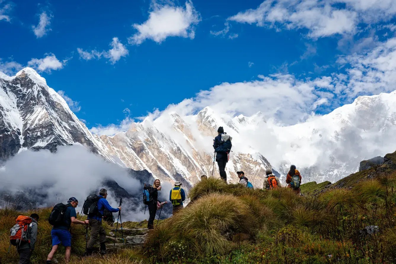Hikers approaching Annapurna Base Camp with snow-covered Himalayan peaks, highlighting the trekking difficulty and high-altitude terrain.