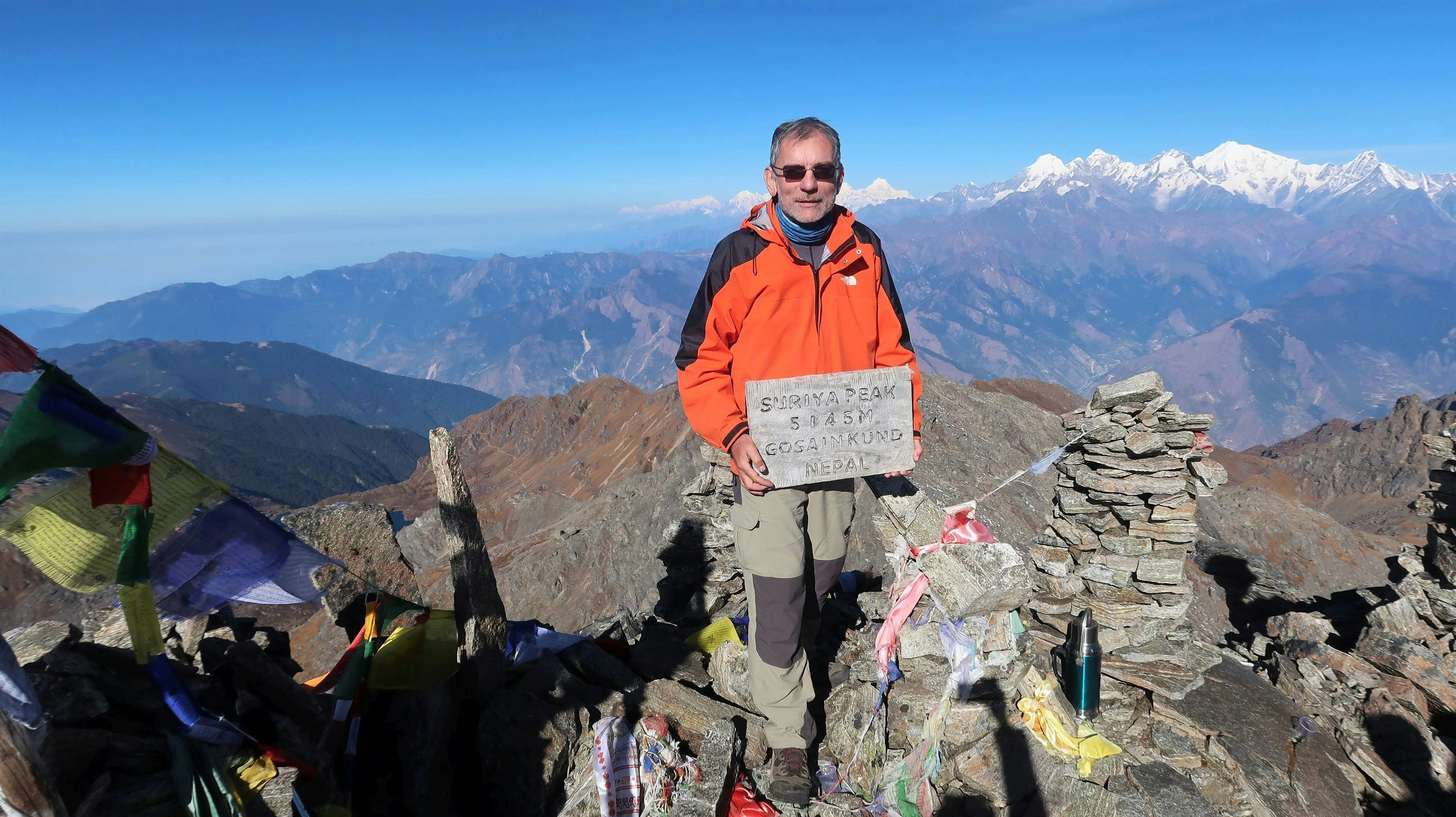 Trekkers at Surya Peak summit overlooking Gosaikunda Lake and Himalayan mountains, trekking in Nepal
