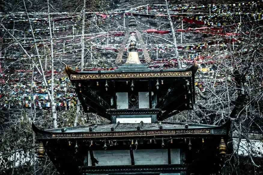 Pilgrims visiting Muktinath Temple in Mustang Nepal with snow-capped Himalayan mountains in the background during a clear morning.