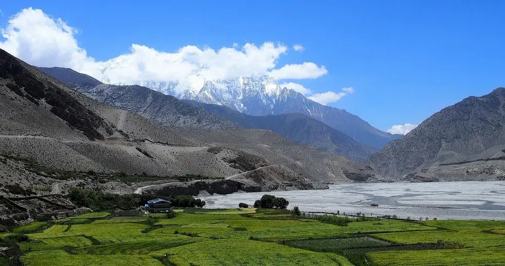 Kagbeni village green fields behind desert hills during Mustang trekking in Nepal