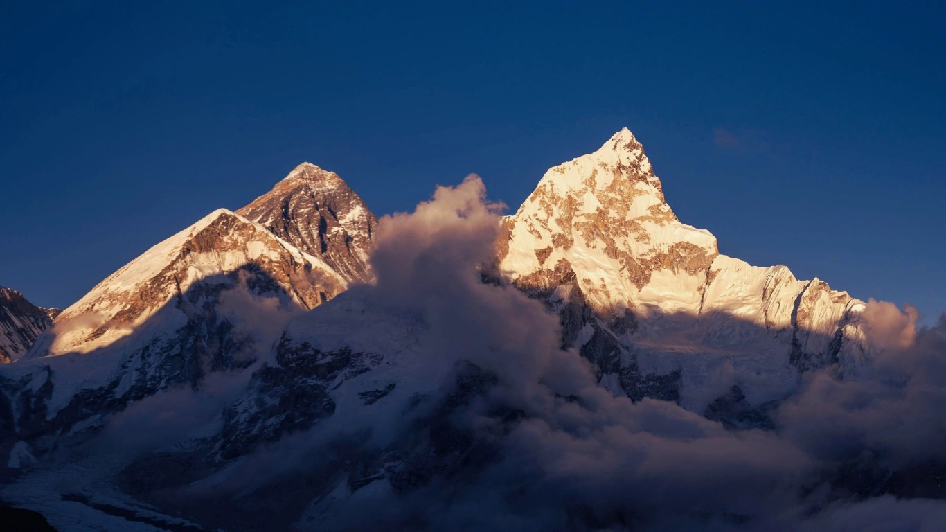 Panoramic view of the Himalayan mountain ranges in Nepal with snow-capped peaks and blue sky