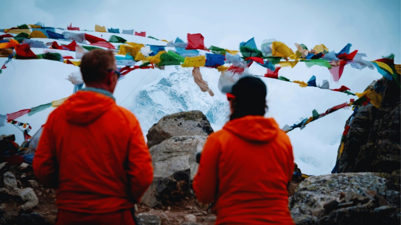 Trekkers pausing to admire the panoramic Himalayan views at Thukla Pass during the Everest Base Camp Trek in winter.