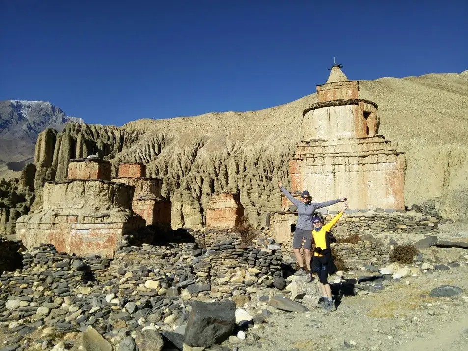 Trekking in Nepal in Upper Mustang with a smiling trekkers exploring the arid Himalayan terrain and traditional villages.