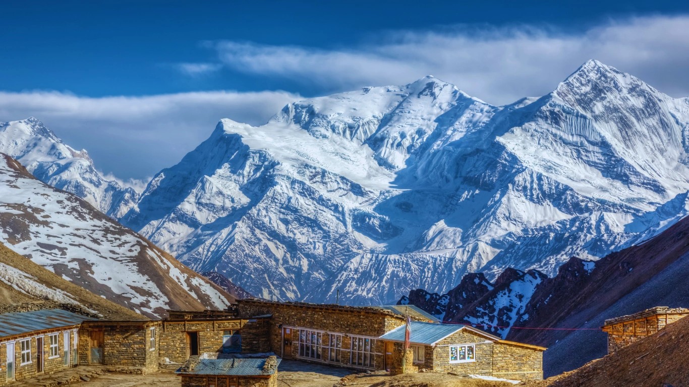 Thorong La Pass under clear blue skies during autumn, considered the best time to trek the Annapurna Circuit for panoramic mountain views.