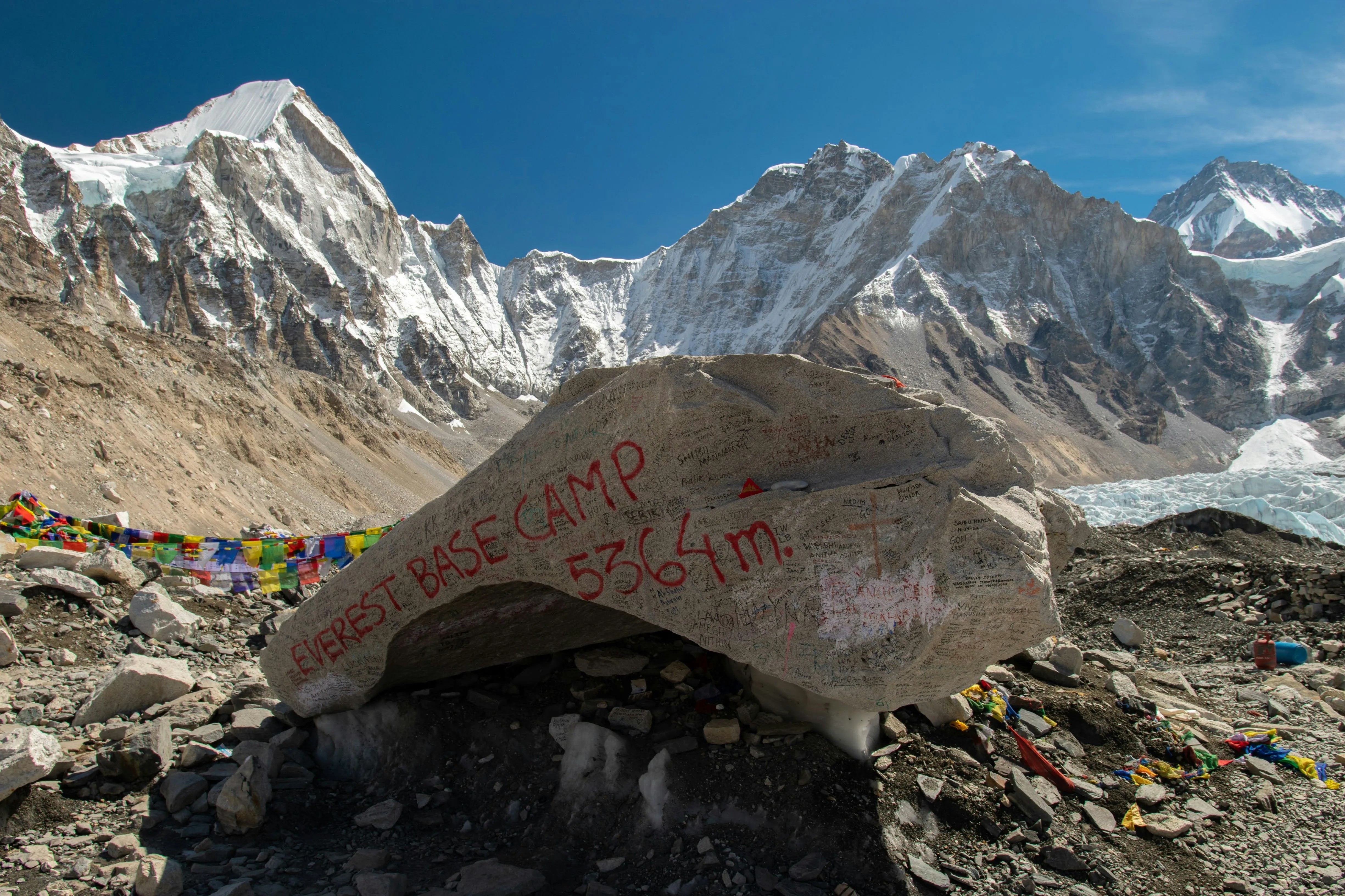 Everest Base Camp Trek Nepal showing trekkers at base camp with prayer flags and Khumbu Icefall mountain views