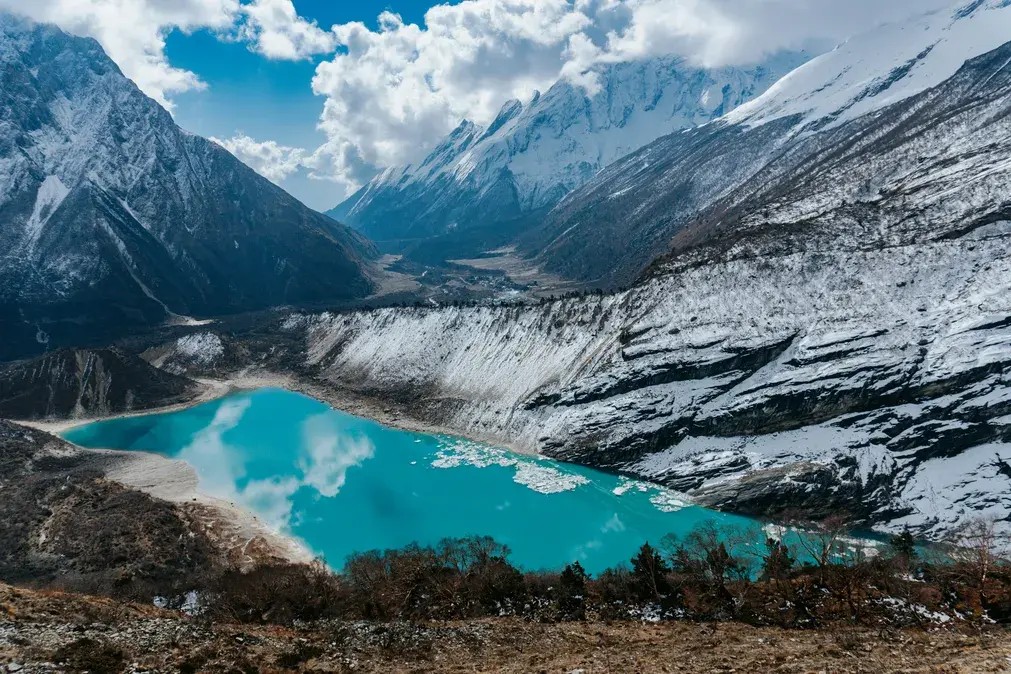 Birendra Lake in the Manaslu region Nepal with clear blue glacial water and mountain backdrop.