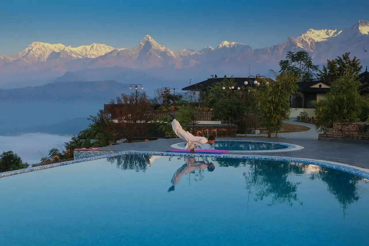 Sunrise yoga instructor leading session during Poon Hill Yoga Trek in Nepal with Annapurna mountain range in the background.