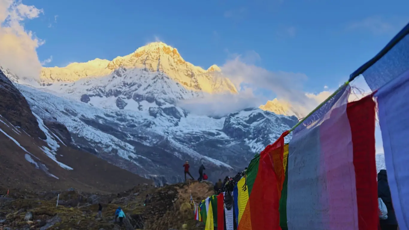 Trekkers enjoying sunrise views of Annapurna South as morning light shines on the snow-capped mountain peaks.